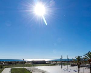 um sol brilhando no céu sobre o oceano em Blue Villa by ALGARVEMANTA na Manta Rota