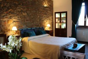 1 dormitorio con cama y pared de piedra en B&B Al Castello, en Casale Litta