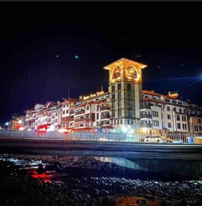 un gran edificio con una torre de reloj por la noche en Boutique lux design apartment @Bansko Royal Towers, en Bansko