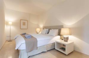 una camera con un grande letto bianco e un comodino di Guesthouse Palma - ADULTS ONLY a Palma de Mallorca