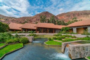 une maison avec une cascade au milieu d'une rivière dans l'établissement Tambo del Inka, a Luxury Collection Resort & Spa, Valle Sagrado, à Urubamba