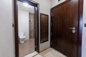 een badkamer met een toilet en een houten deur bij Luxury Studio Apartment - Varna Residens in Varna