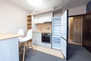 een keuken met een koelkast en een tafel en stoelen bij Luxury Studio Apartment - Varna Residens in Varna