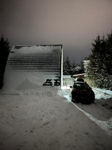 un'auto parcheggiata in un parcheggio coperto di neve di U Yaroslava Hotel a Jaremče