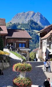 eine Kopfsteinpflasterstraße in einem Dorf mit einem Berg in der Unterkunft Hôtel de Ville in Gruyères