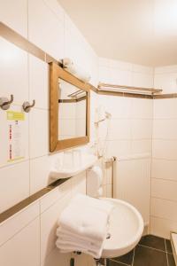 a white bathroom with a sink and a mirror at Hotel Andres in Bamberg