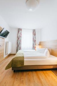 a large white bed in a room with a window at Hotel Andres in Bamberg