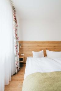 a bedroom with a white bed and a window at Hotel Andres in Bamberg