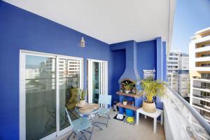 um quarto azul com uma varanda com uma mesa e cadeiras em Belo Horizonte Studio- Pet Friendly em Portimão