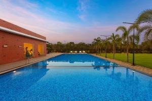 - une grande piscine à côté d'un bâtiment en briques dans l'établissement Fortune Park Airport Road, Hubballi - Member ITC's Hotel Group, à Hubli