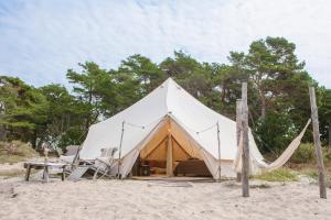 duży namiot na plaży z krzesłami i stołem w obiekcie Surflogiet Gotland w mieście Tofta