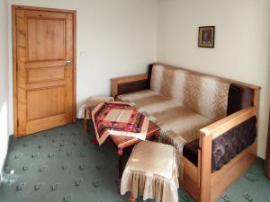 Zimmer mit Sofa, Tisch und Tür in der Unterkunft Guest Rooms Grachenovi in Bansko