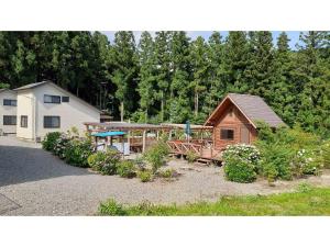 une maison avec une terrasse couverte et une cour ornée de plantes dans l'établissement Sudomari no Yado Sunmore - Vacation STAY 46722v, à Nikkō