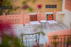 a patio with chairs and a table and a fence at Rawla Rawatsar in Jaipur