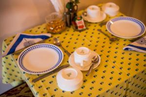 a table with plates and cups and spoons on it at Rawla Rawatsar in Jaipur