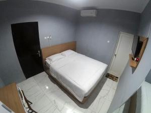 Un pat sau paturi într-o cameră la Polkesyo Homestay Jogja