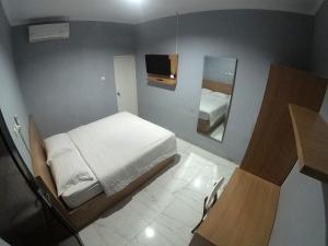 Un pat sau paturi într-o cameră la Polkesyo Homestay Jogja