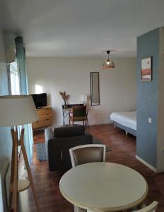 een woonkamer met een bed en een tafel bij Résidence Carouge Appart Hôtel in Brétigny-sur-Orge