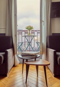 Zimmer mit einem Tisch und Blick auf einen Balkon in der Unterkunft Hotel Petit Lafayette in Paris