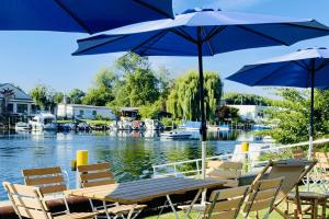 un tavolo e sedie con ombrelloni accanto a un fiume di havelblau Ferienlofts a Brandenburg an der Havel