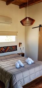 um quarto com uma cama grande com duas toalhas em Malvón em Cafayate