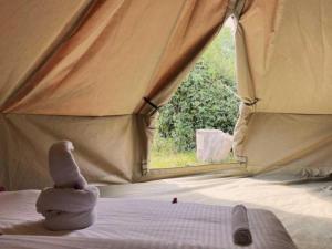 um animal de peluche numa cama numa tenda em The Jungle Pearl Resort em Mto wa Mbu