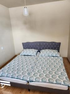 Ce lit se trouve dans un dortoir doté d'une couette bleue et blanche. dans l'établissement Apartmán Greenside, à Michalovce