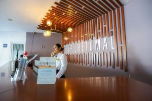 un homme debout à un comptoir dans un bureau dans l'établissement TRYP by Wyndham Chetumal, à Chetumal