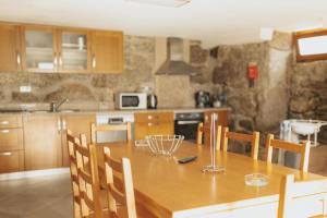 cocina con mesa de madera y sillas en Quinta do Rabelo, en Braga