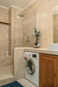 a washing machine in a bathroom with a shower at Grand Large - Premium suite in Papeete