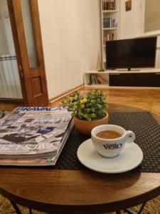 una tazza di caffè e una pianta in vaso sul tavolo di Apartman Veselinovic Free PARKING a Vranje