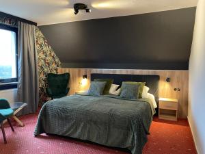 a bedroom with a large bed and a chair at Berghotel Hohegeiß in Hohegeiß