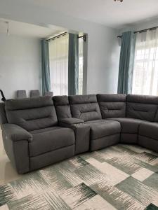 ein großes braunes Sofa im Wohnzimmer in der Unterkunft Zoe Homes 1br and 2br Apartment Greypoint 406 in Kericho