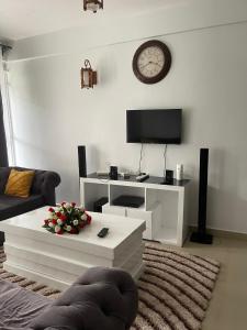 ein Wohnzimmer mit einem TV und einem Couchtisch in der Unterkunft Zoe Homes Greypoint 1br and 2br Apartment 101 in Kericho