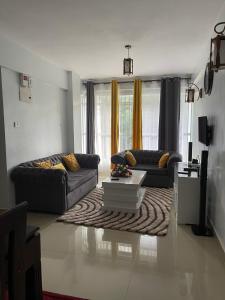 ein Wohnzimmer mit 2 Sofas und einem Couchtisch in der Unterkunft Zoe Homes Greypoint 1br and 2br Apartment 101 in Kericho