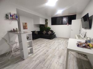 uma sala de estar com um sofá preto e um piso de madeira em Sweet Apt Charco by flamingo house em Arrecife