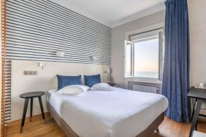 Un pat sau paturi într-o cameră la Hotel Kyriad Saint Malo Centre Plage