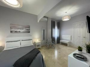 a bedroom with a large bed and a room with a table at Villa TRIANA in Seville