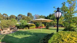 einen Park mit einem Regenschirm und einer Straßenbeleuchtung in der Unterkunft Glider City Motel Benalla in Benalla