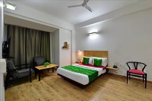 a hotel room with a bed and a desk and a chair at Divine Inn Couple Friendly Hotel near Sector 51 Metro Station in Noida