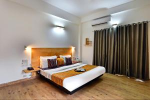 a bedroom with a large bed and a large window at Divine Inn Couple Friendly Hotel near Sector 51 Metro Station in Noida