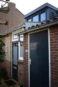 Cette maison individuelle dispose d'un garage noir et de fenêtres. dans l'établissement ZeeBedStay, à Noordwijk aan Zee