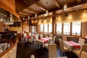 ein Restaurant mit Tischen und Stühlen und eine Bar in der Unterkunft Apart & Spa Zoned in Kopaonik