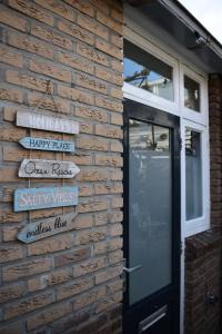 un mur en briques avec des panneaux à côté d'une porte dans l'établissement ZeeBedStay, à Noordwijk aan Zee