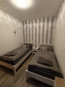 - une chambre avec 2 lits et un mur avec des rayures dans l'établissement Lütt Nest Föhr, à Alkersum