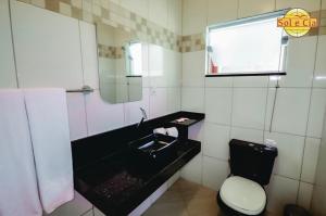 a bathroom with a sink and a toilet at Pousada Sol e Cia Tur in Caraguatatuba