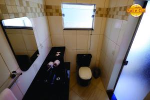 a small bathroom with a toilet and a sink at Pousada Sol e Cia Tur in Caraguatatuba