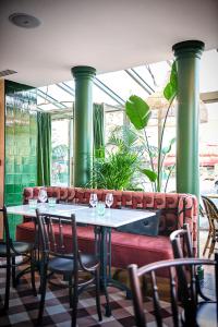 een tafel en stoelen in een restaurant met groene zuilen bij Maison Eugenie in Parijs