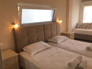 1 dormitorio con 2 camas y TV en la pared en see the sea1, en Kassiopi