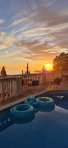 une piscine avec vue sur le coucher du soleil en arrière-plan dans l'établissement Ashram Villa Sunshine, à Sitges